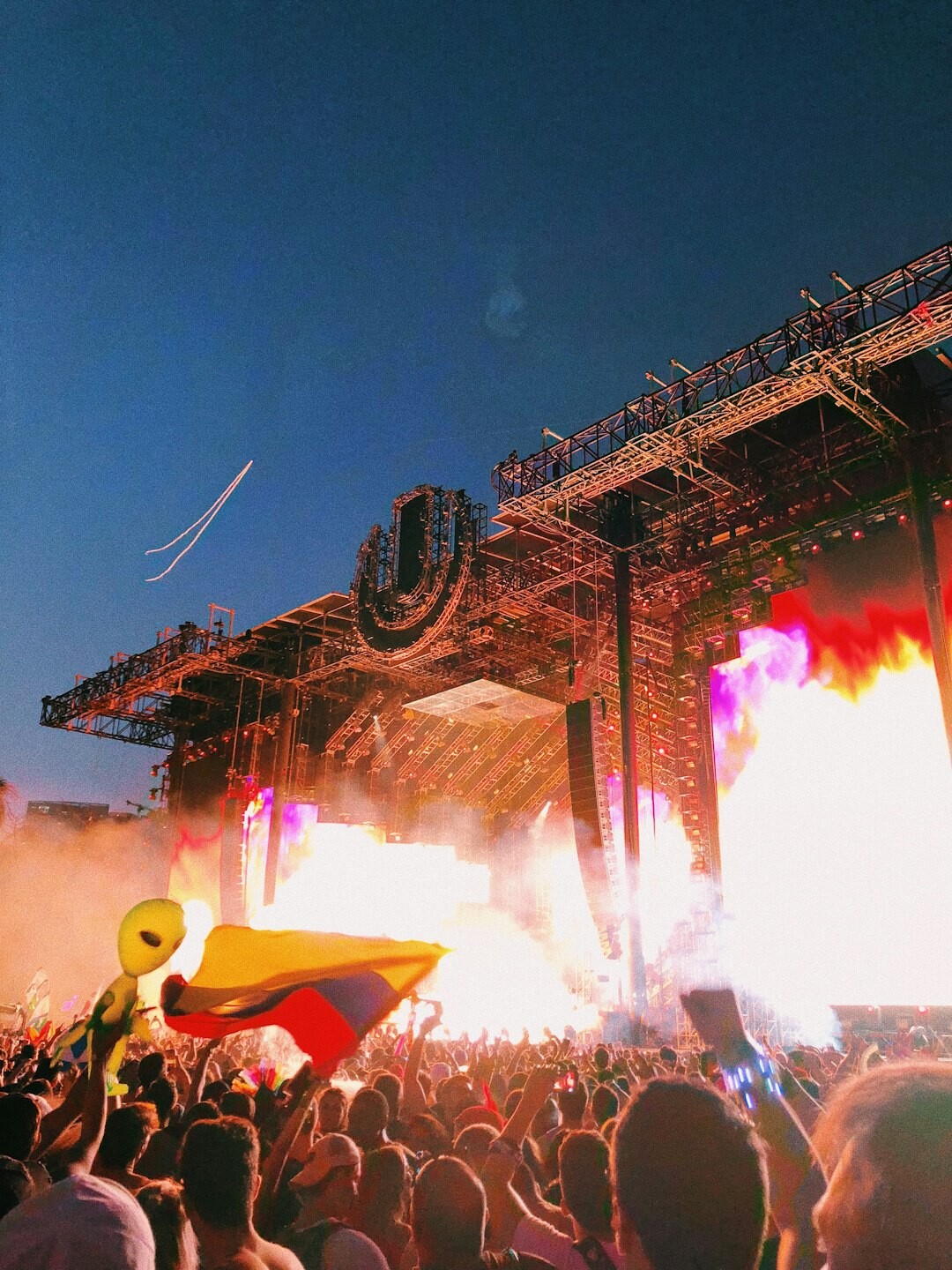 Outdoor festival stage with crowd and colorful lighting